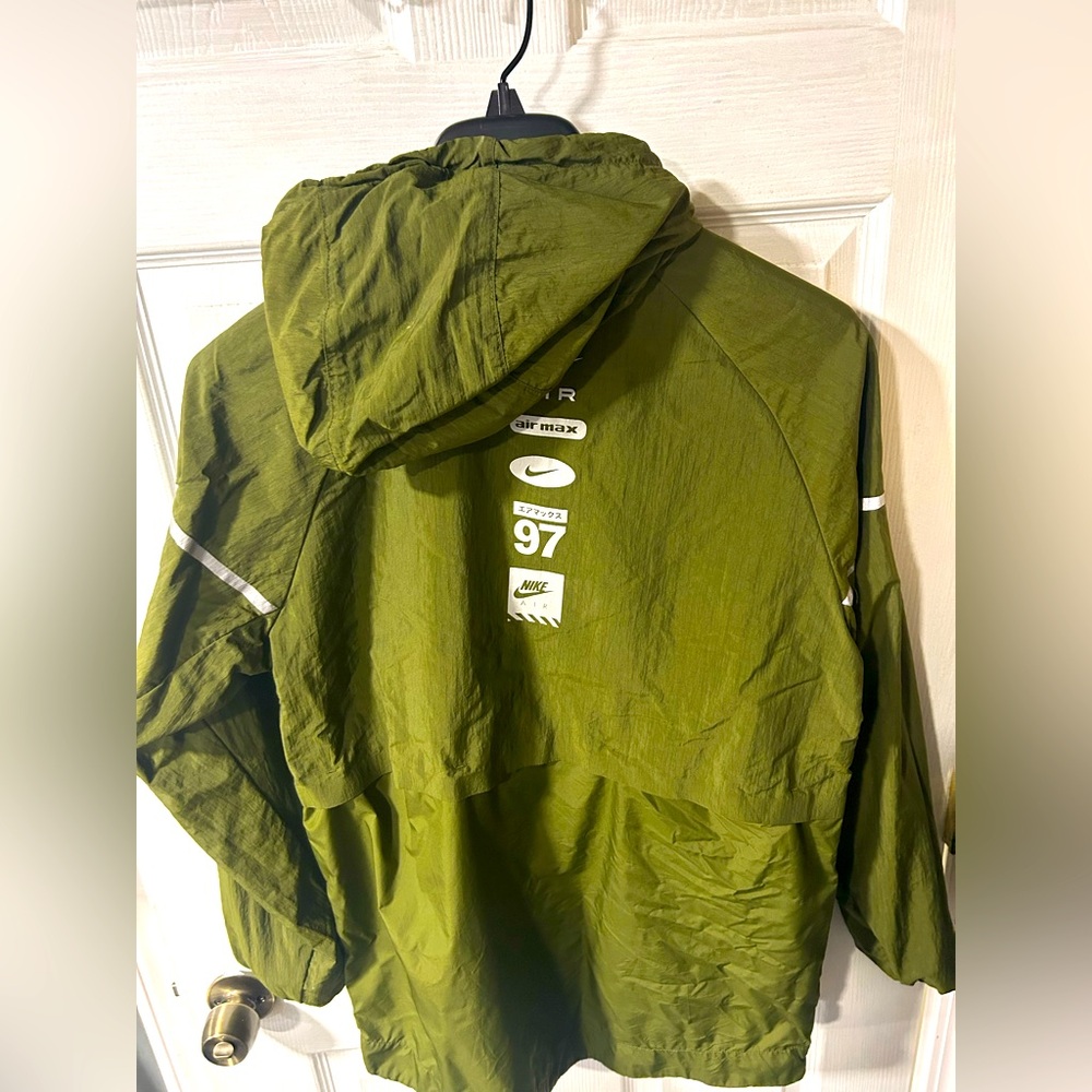 Nike windbreaker moderately worn . 1 burn hole .